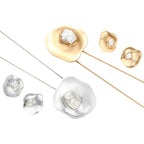 Organic-shaped eco-zinc alloy stud earrings with resin pearl centers and sterling silver posts on white background.