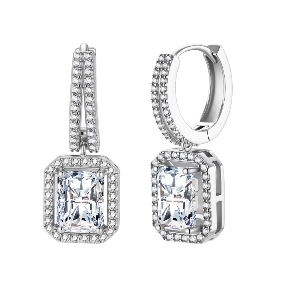 Sterling silver huggie hoops with emerald-cut moissanite drops featuring pavé-set crystals on white background.