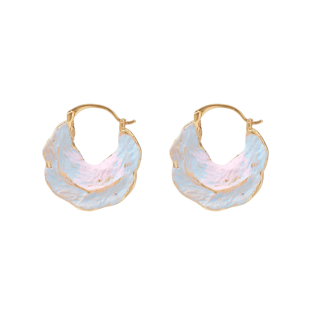 Shell-shaped hoop earrings with iridescent blue-pink enamel and gold trim on cream background