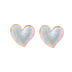 Heart-shaped stud earrings with swirled turquoise and pink enamel in gold-plated frames on cream background