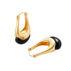 Gold-plated drop earrings featuring black agate stones with hoop closure on white background, showing elegant teardrop design.