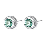 Round green moissanite stud earrings in sterling silver halo settings with brilliant sparkle on white background.