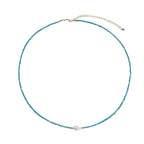 Delicate gold vermeil necklace with teal apatite beads and freshwater pearl on white background.