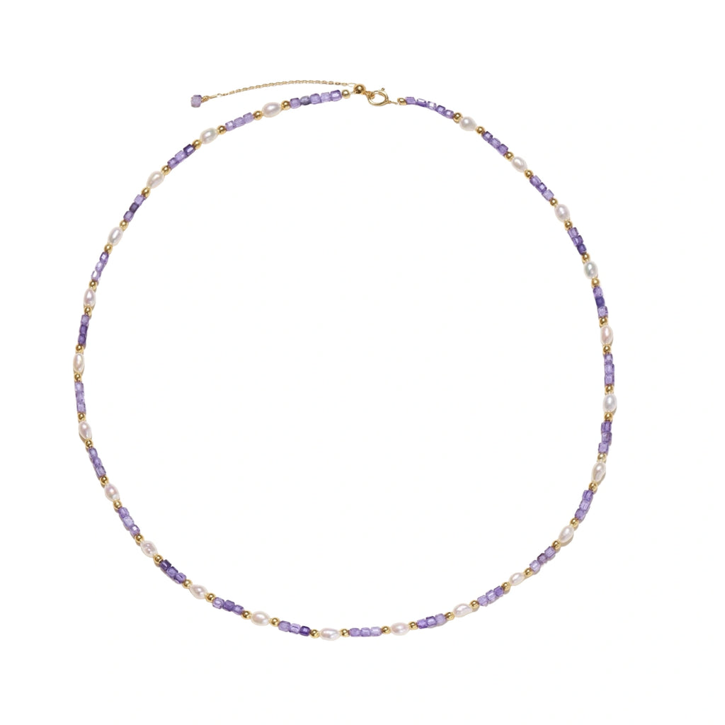 Delicate 18K gold vermeil necklace with alternating lavender zirconia beads and white freshwater pearls on cream background