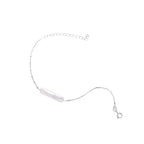 Minimalist bracelet with iridescent baroque pearl on rhodium-plated sterling silver chain against cream background