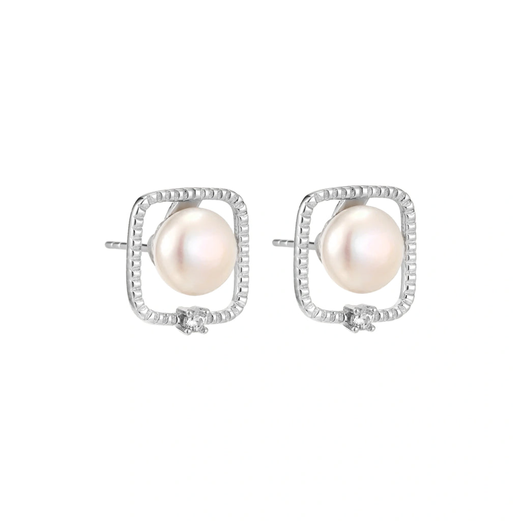 Rhodium-plated silver stud earrings with cushion frame, centered freshwater pearl, and tiny crystal accent