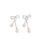 Rhodium-plated silver earrings with organic vine curves and two peachy freshwater pearls on cream background