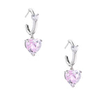 Silver huggie hoops with pink heart-cut zirconia pendants on white background, eco-friendly white gold plated brass