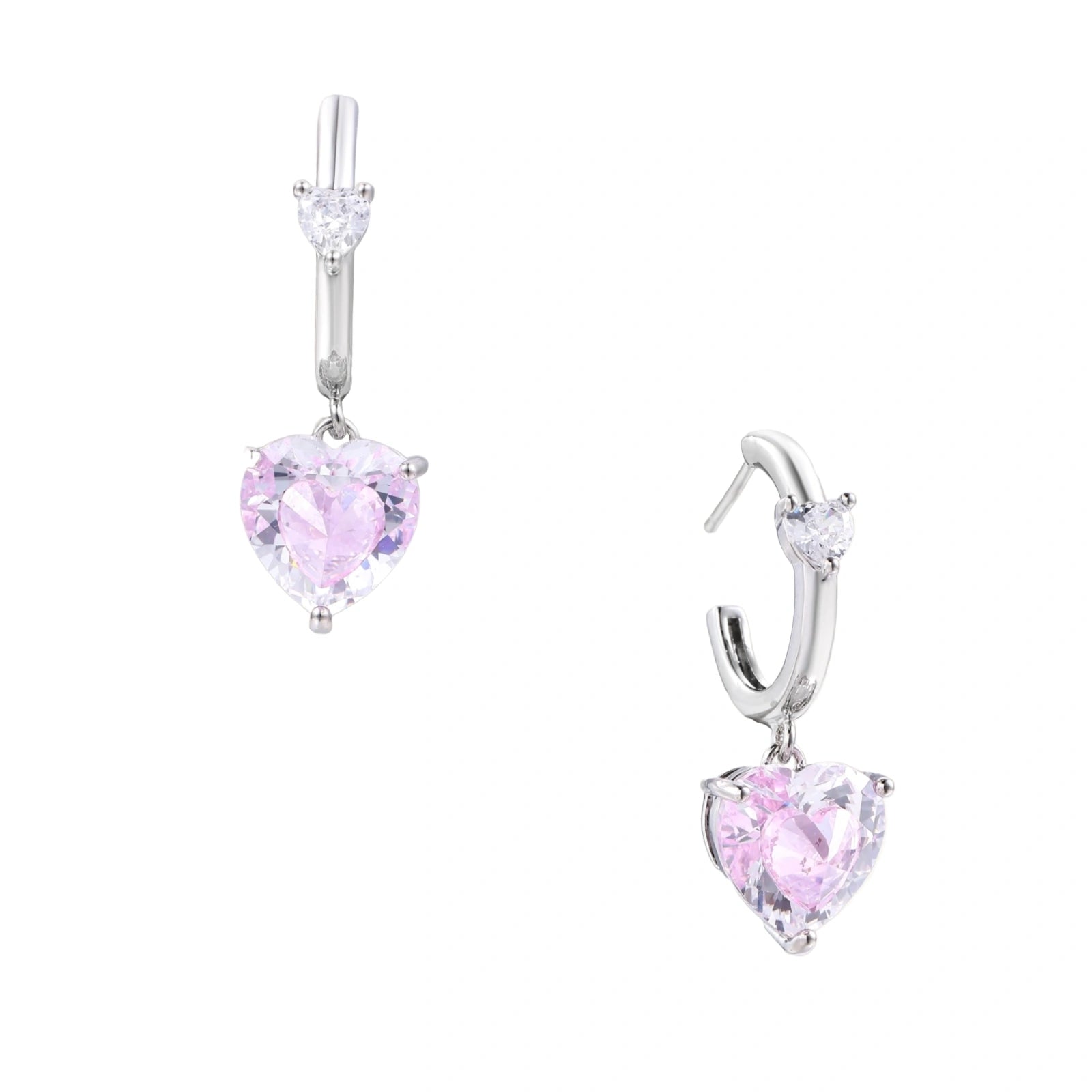 Silver huggie hoops with pink heart-cut zirconia pendants on white background, eco-friendly white gold plated brass