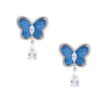 Blue denim butterfly earrings with silver frame and teardrop crystal dangles on cream background