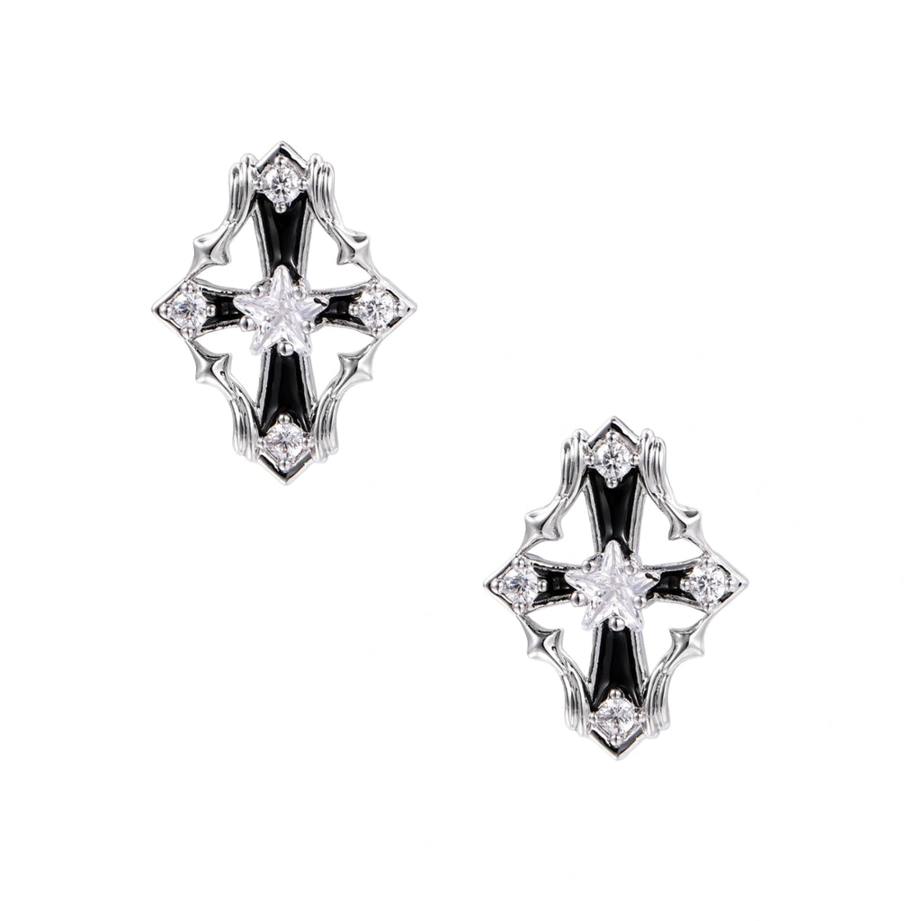 Pair of Art Deco-style stud earrings with star crystals, black enamel accents, and white gold plating on ivory background.