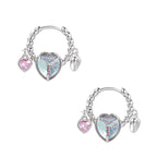 Silver chain hoop earrings with iridescent opal heart charms and pink zirconia accents on white background