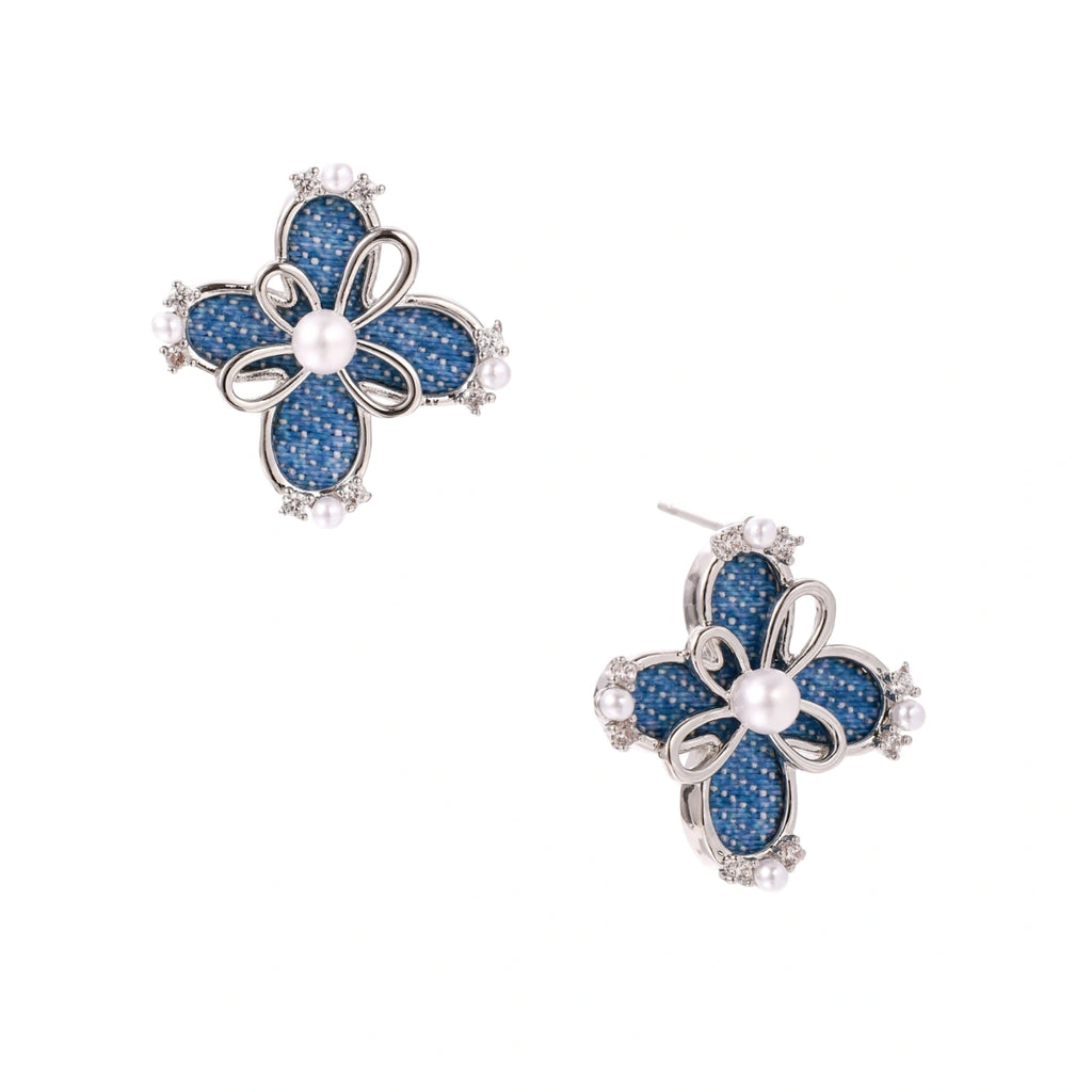 Blue denim fabric flower studs with white gold plated petals, pearl center, and zirconia accents on white background