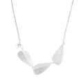 Minimalist sterling silver necklace with three brushed leaf-shaped pendants on delicate chain against white background
