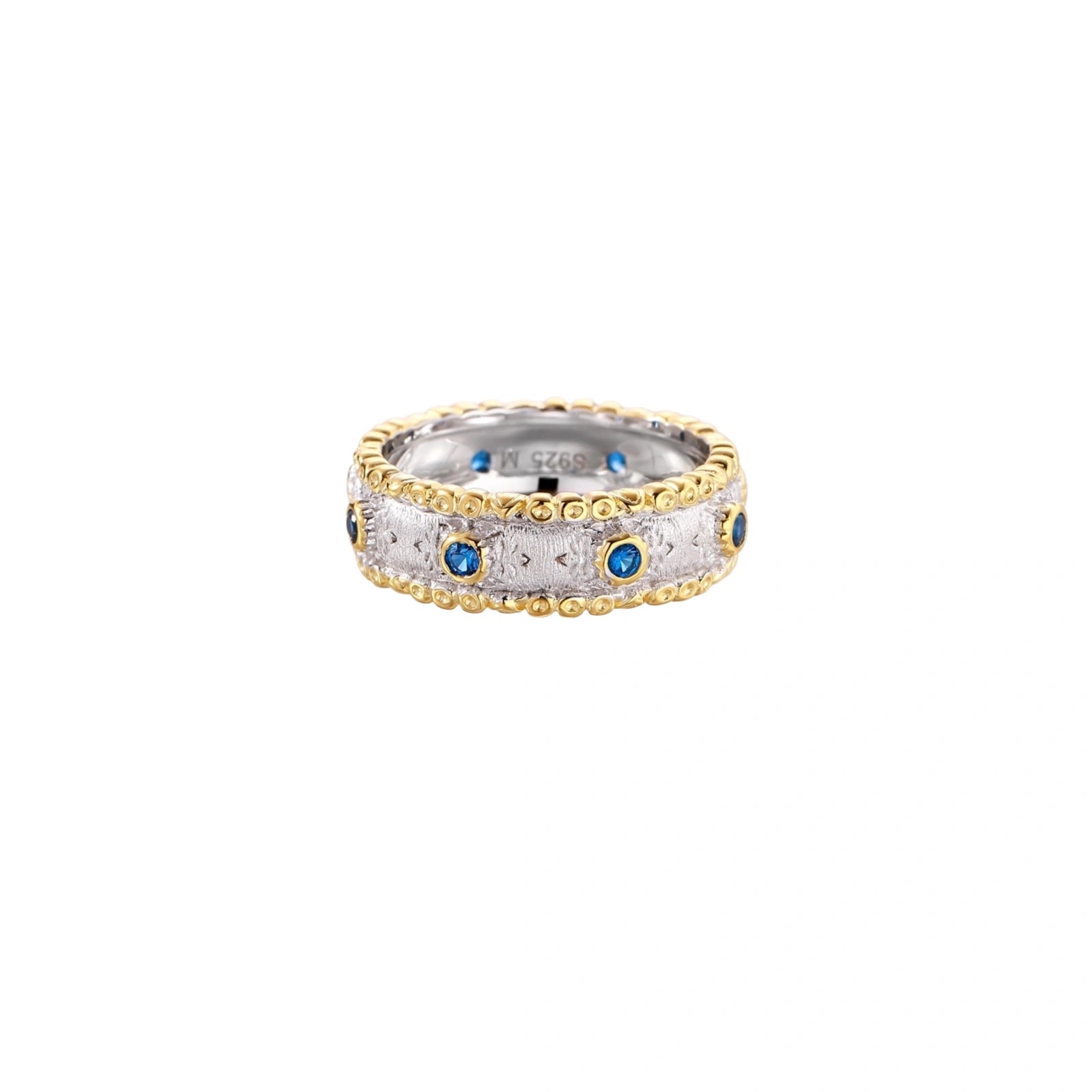 Two-tone ring with brushed silver center, gold beaded edges, and blue zirconia stones on white background.