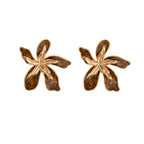 Gold-plated brass flower earrings with brown tortoiseshell enamel petals on cream background