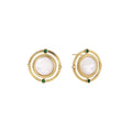 Circular gold stud earrings with iridescent mother-of-pearl center and green zirconia accents on cream background.