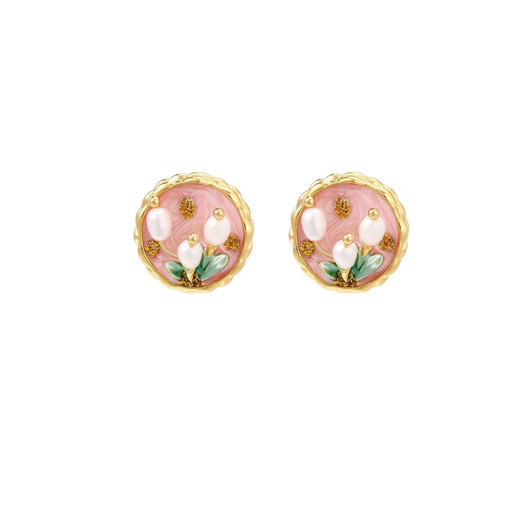 Round stud earrings with pink enamel, three white freshwater pearls, green leaves, and gold-plated braided border