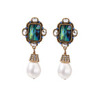 Ornate gold-plated drop earrings with rectangular abalone shell centers, crystal accents, and baroque pearl drops