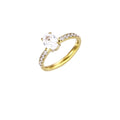 Gold-plated solitaire ring with oval zirconia center stone and pavé band on cream background