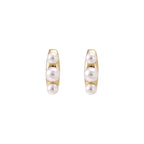 14K gold-plated curved stud earrings with three white freshwater pearls aligned vertically on cream background