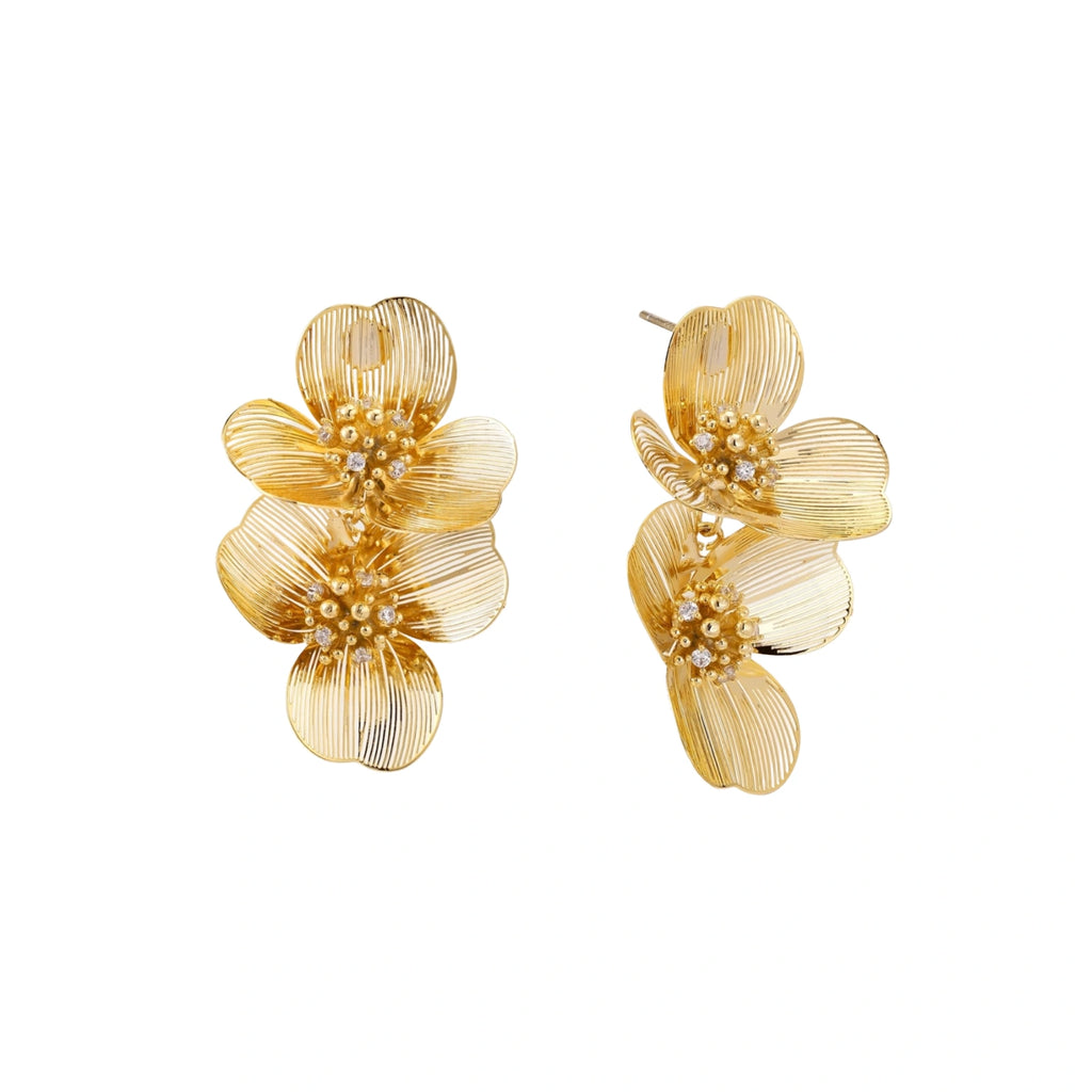 Pair of gold-plated double flower earrings with textured petals and crystal centers on cream background.
