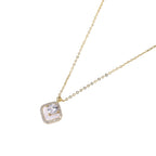 Gold quatrefoil pendant with crystal center on iridescent mother-of-pearl base, adjustable gold chain on cream background