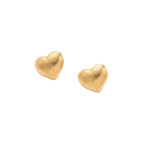 Gold heart-shaped stud earrings with parallel ridged texture on cream background