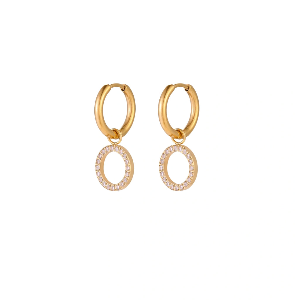 Gold-plated huggie hoop earrings with CZ-studded open circle charms on beige background