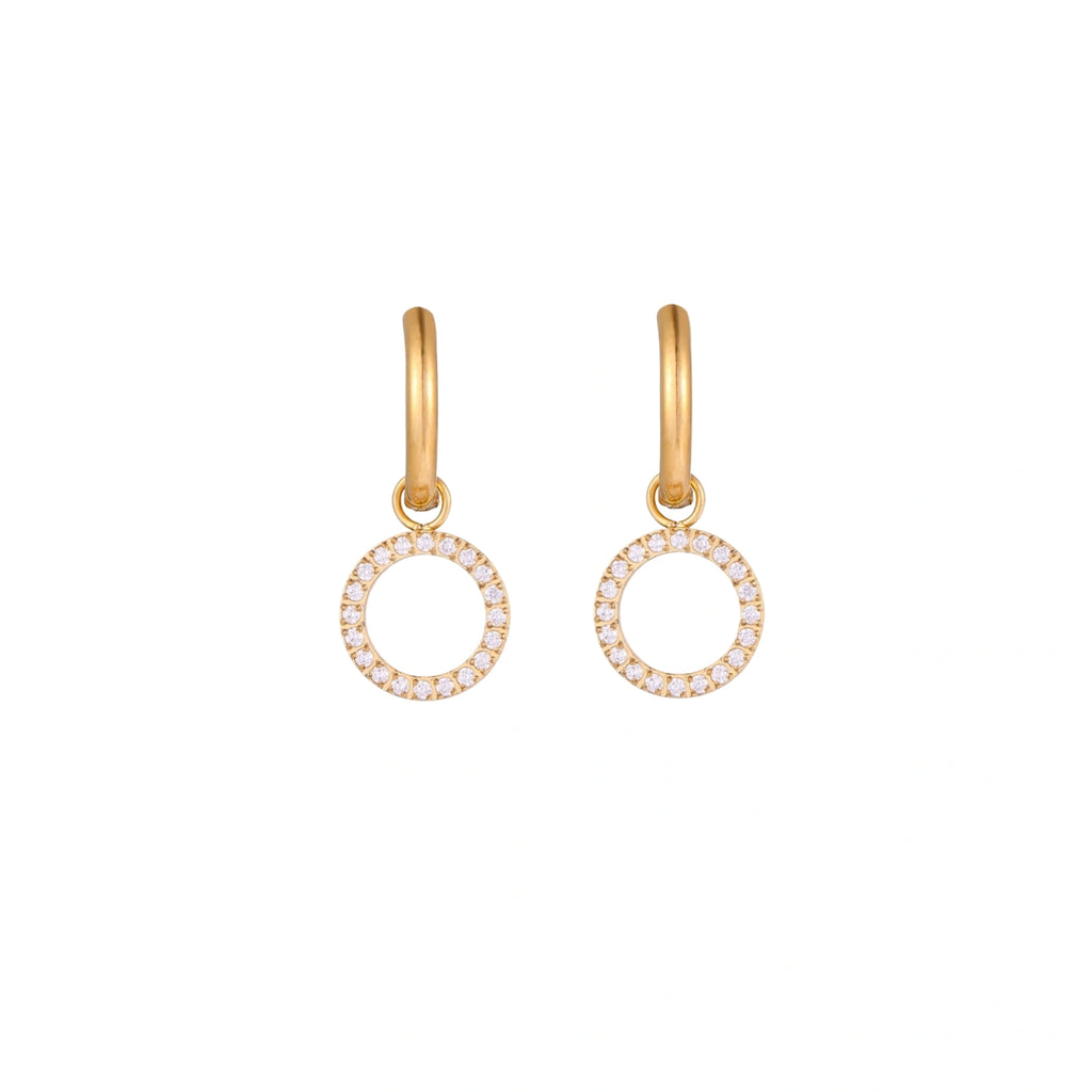 Gold-plated huggie hoop earrings with CZ-studded open circle charms on beige background