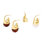 Modern drop earrings with curved gold-plated copper tops and amber resin bottoms creating an organic teardrop silhouette.