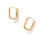 Sculptural gold-plated hoop earrings with flowing curved design and lever-back closure on cream background.