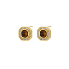 Gold-plated octagonal stud earrings with brown tiger's eye centers and cubic zirconia border on cream background.