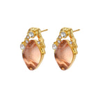 Gold-plated baroque stud earrings with coral-pink liuli stones and cubic zirconia crystals on white background.