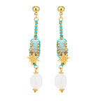 Gold-plated dangle earrings with turquoise threading, star charms, and white pearl beads against cream background.