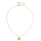 Layered necklace with green stone beads, gold spacers, white accents, and protective eye pendant on cream background.