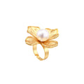 Gold-plated flower ring with textured petals and white cotton pearl center on cream background