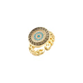 Gold chain ring with Greek key border and turquoise evil eye center on white background
