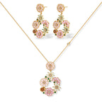 14K gold plated jewelry set with pink and green cubic zirconia flowers arranged in wreath design on cream background