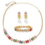Gold-plated jewelry set with pink, turquoise and red flower-shaped cubic zirconia stones, featuring necklace, earrings and bracelet.